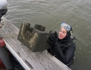 UCI Marine Biology Technician Amanda Boddy adds an oyster castle to the reef at Naval Weapons Station Earle.