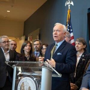 Former UCI director Tony MacDonald at podium
