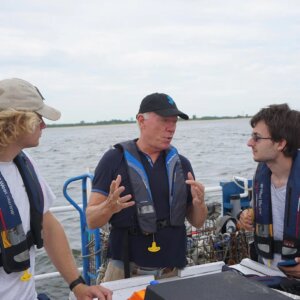MacDonald speaks to two students aboard a vessel