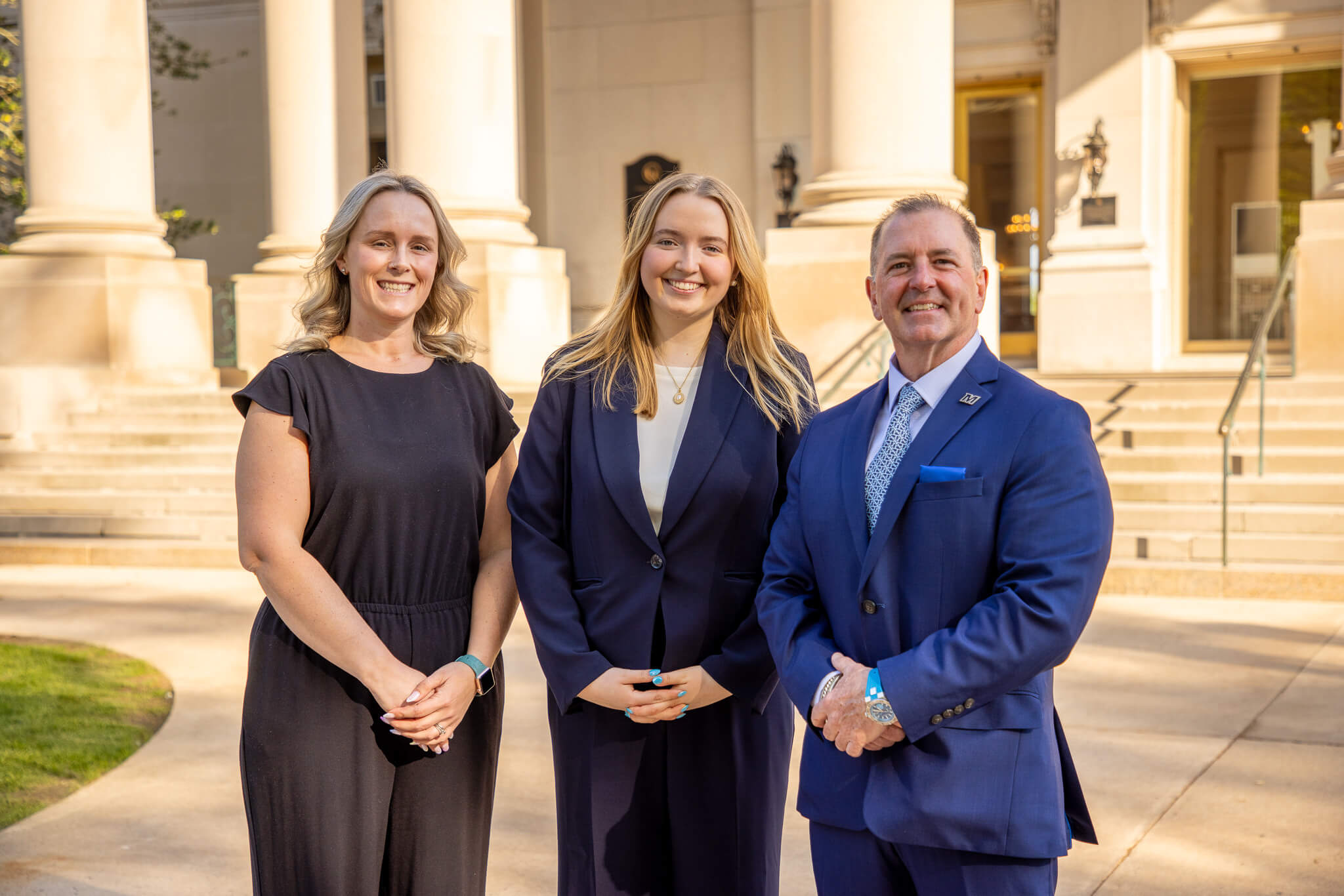 Professor Meg Forney, graduate student Sarah Bilotta, and Professor Douglas Collier pose in front of the Great Hall