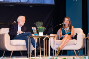 Professor Mihaela Moscaliuc reading her work on stage at a poetry gala