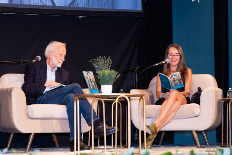 Professor Mihaela Moscaliuc reading her work on stage at a poetry gala