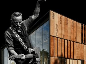 Composite image of Bruce Springsteen playing guitar superimposed on exterior of new building