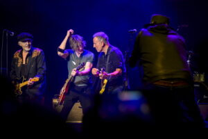 Bruce Springsteen plays guitar on stage under dramatic lighting