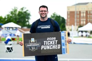 Man holding sign noting NCAA ticket punched for 2026