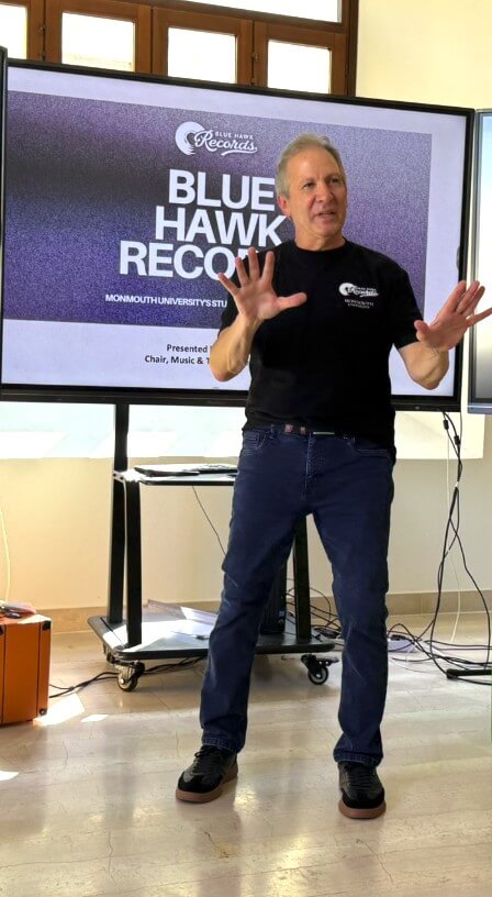 Man standing in front of presentation screen with text reading, Blue Hawk Records