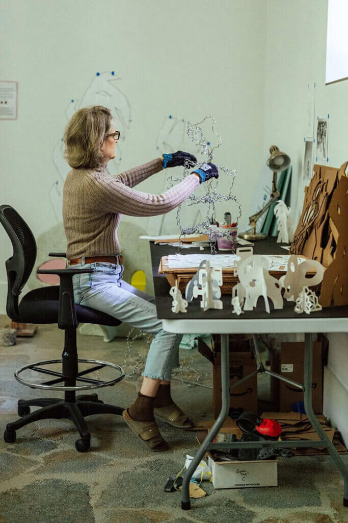 Susan Meyer in an art studio working on a sculpture