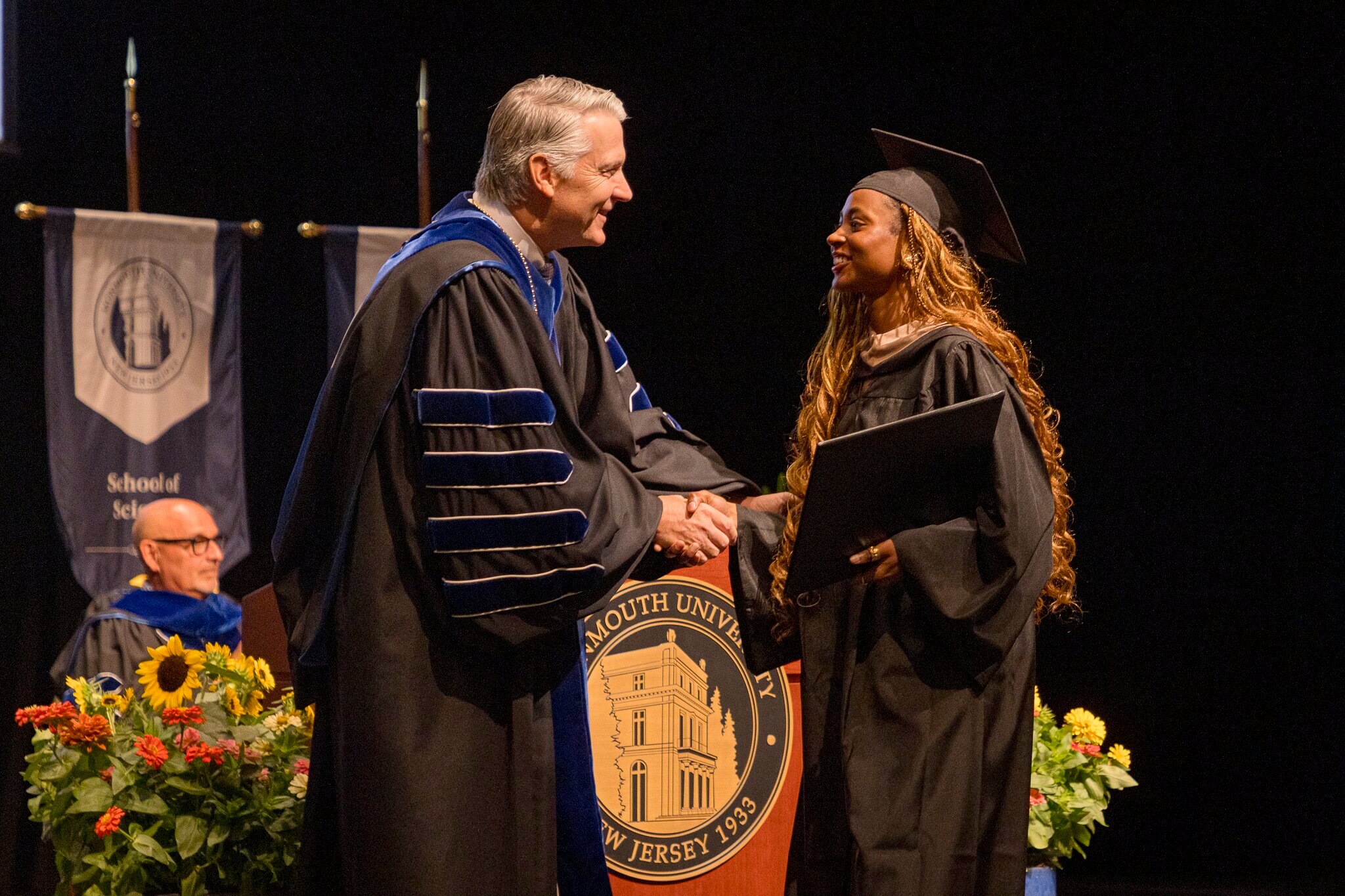 President Patrick Leahy shaking hands with a graduate during a commencement ceremony