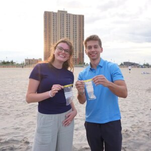 Two students standing on the beach in Asbury Park