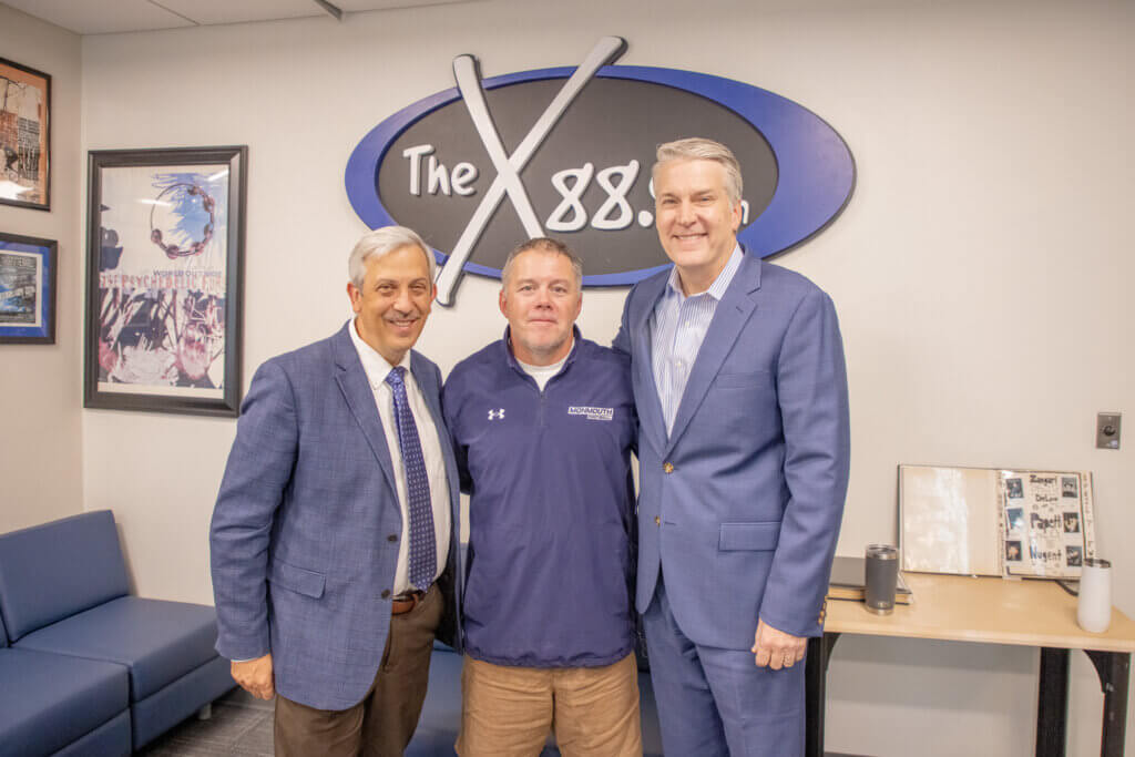 Provost Rich Veit, Prof. Matt Harmon, and President Patrick Leahy standing in offices of WMCX radio station at Monmouth University