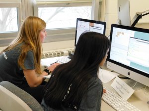 Two female students from Middletown High School South facing their computers at the competition