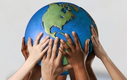 Hands holding up a clay globe