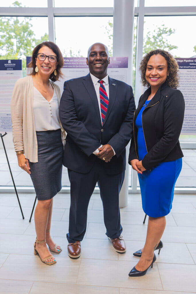 Three professionals smiling and posing for a photo together