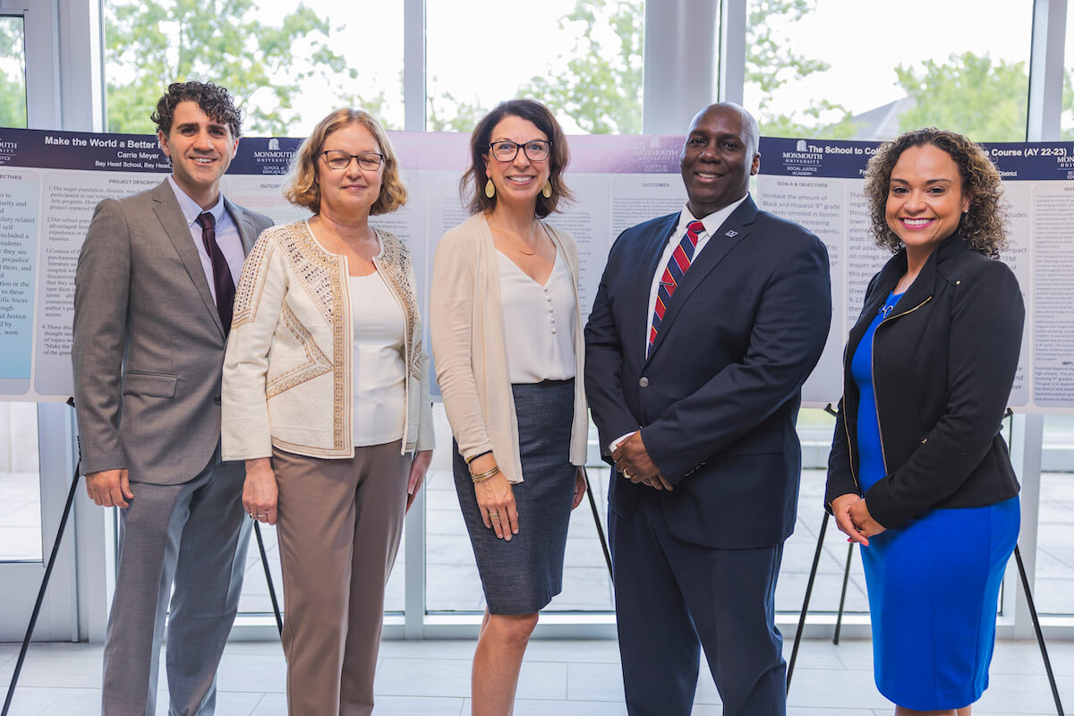 Five professionals posing for a photo together