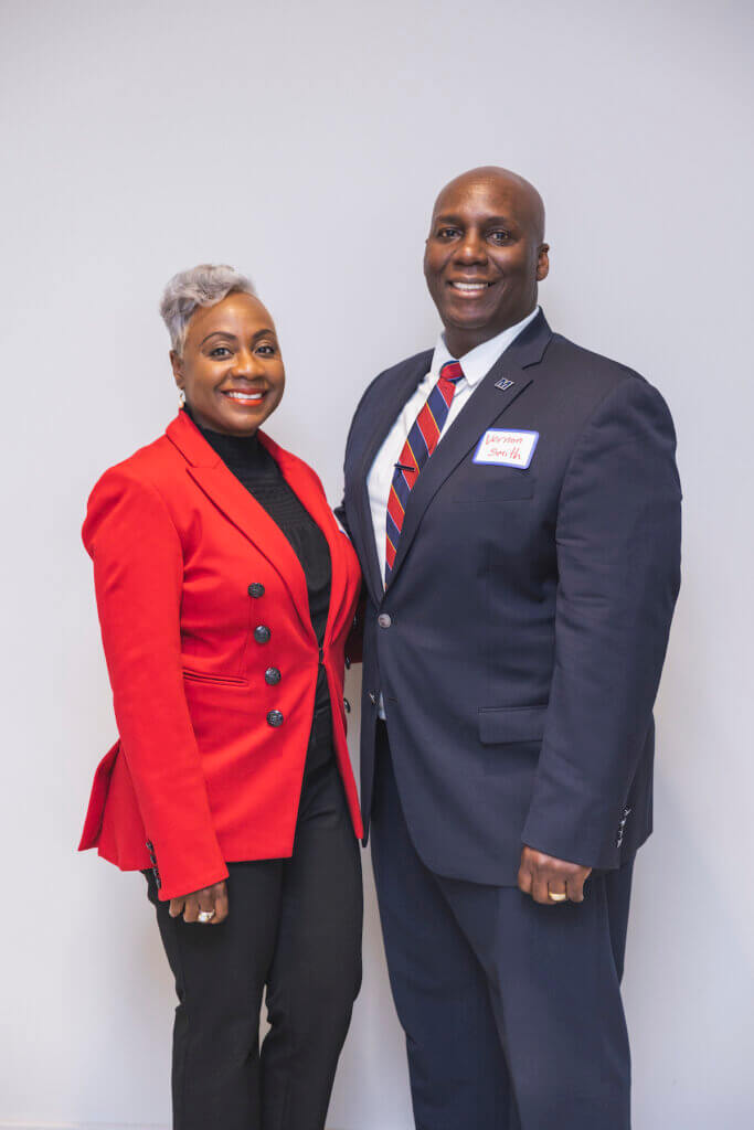 Two professionals smiling and standing together for a photo