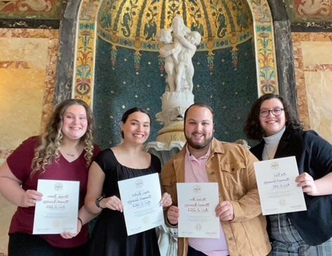 A group of students holding their certificates stating they are new members of Kappa Delta Phi. 