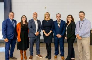 Six people in professional attire standing together for a photo