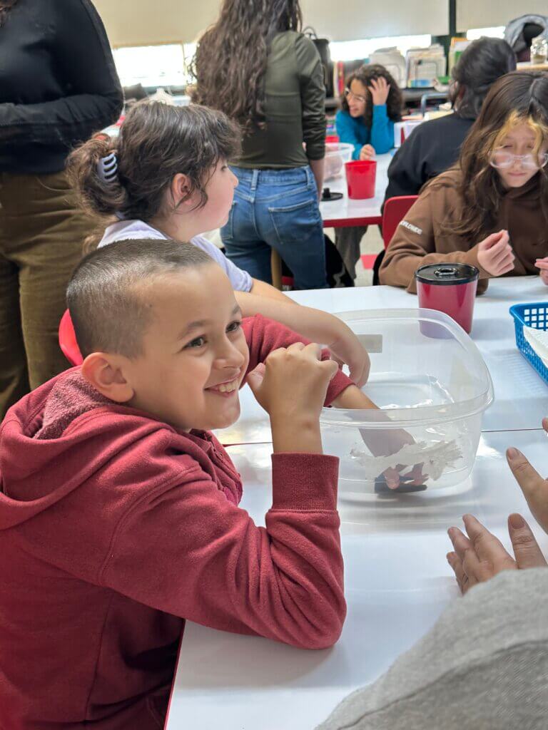 Students smiling and participating in interactive planting activities.