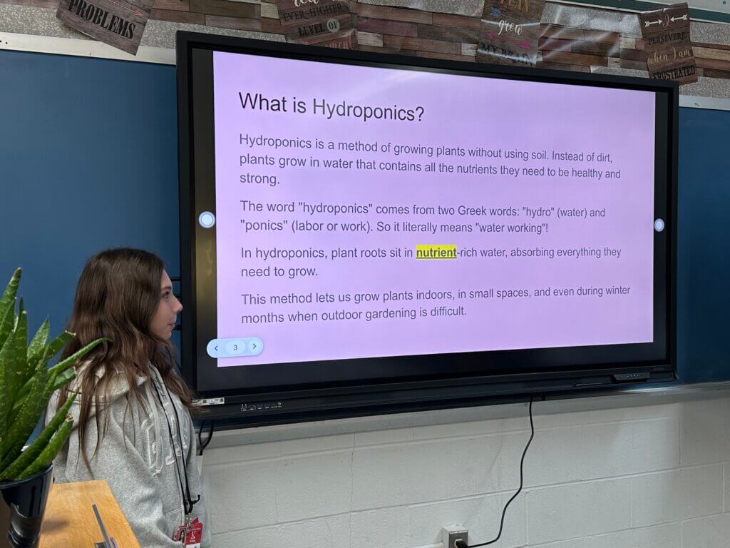A student delivering a presentation on hydroponics.