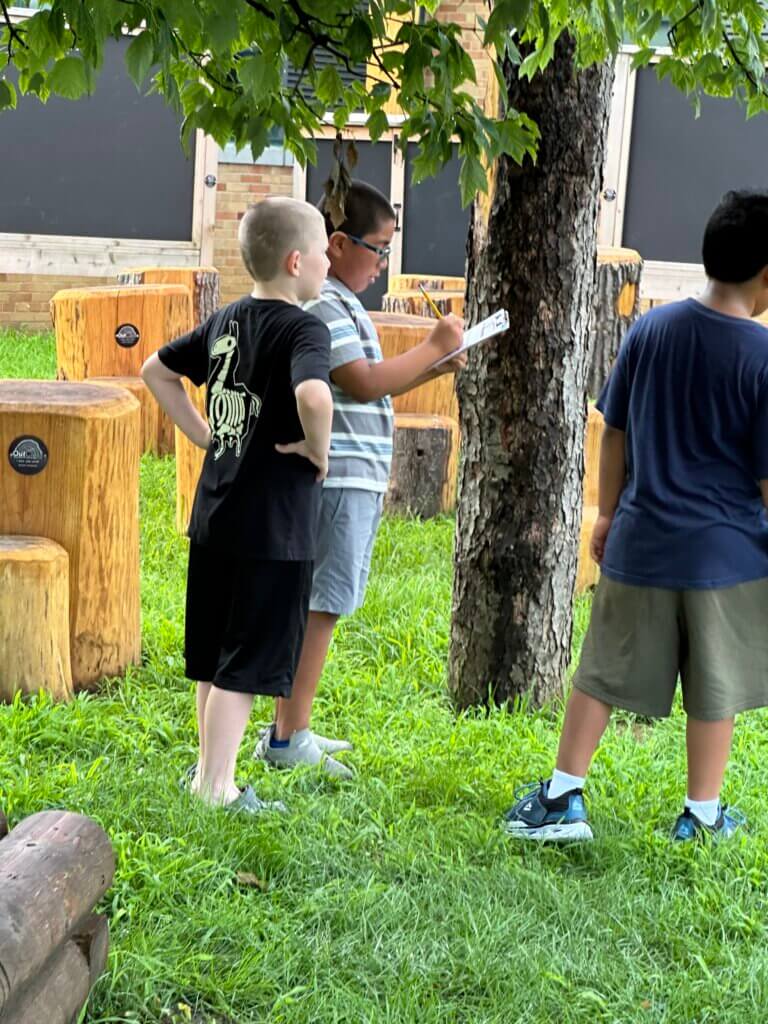 Students taking notes outside together.