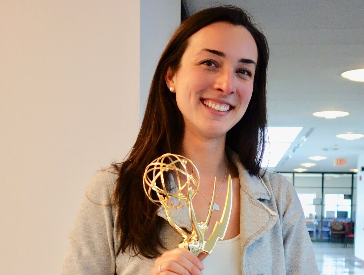 Katharine Gibson '13, shown in this shot with her Emmy statuette, studied TV and Radio here at Monmouth.