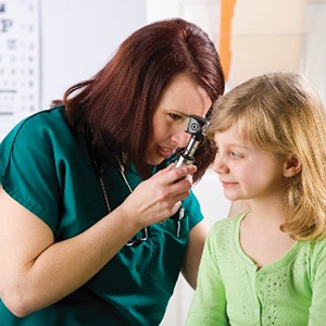 School nurse examining a child's ear