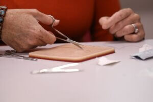 Nurse practitioner bootcamp student practicing how to suture.
