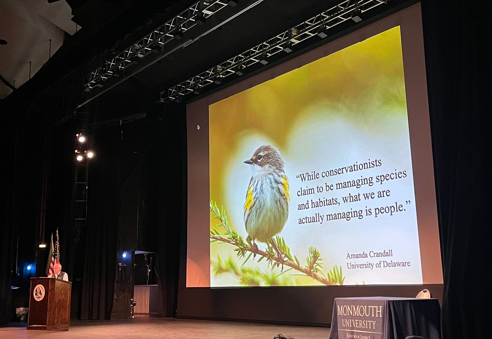 man speaking in front of slide with bird, slide is about managing people.