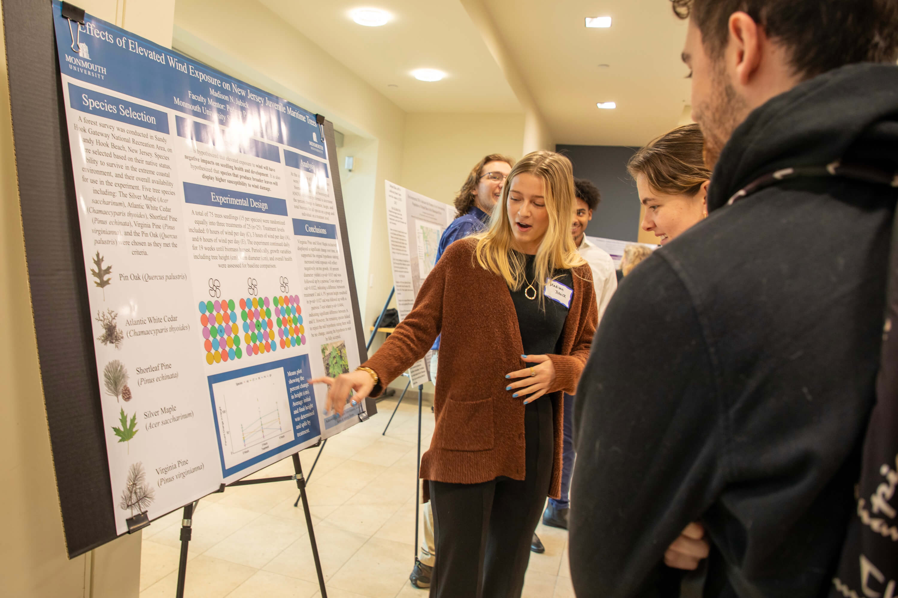 a young woman indicating an image on her poster to listeners