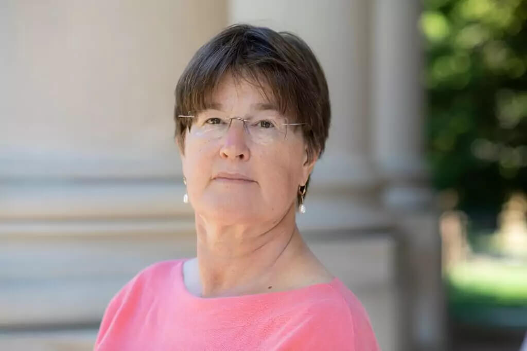 Catherine Duckett standing by the columns of the Great Hall