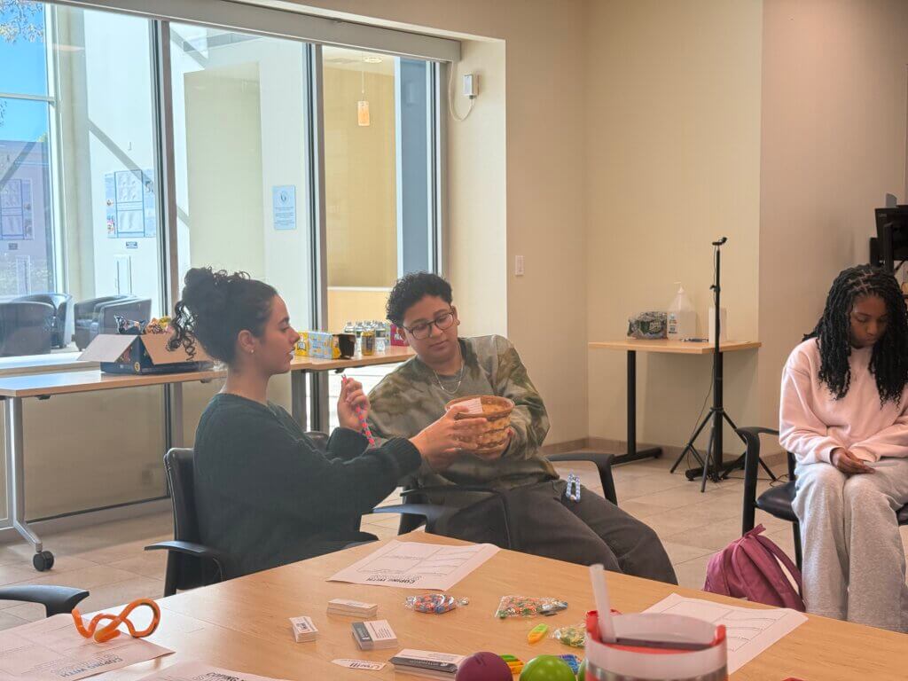 Three people sit around, share a basket.