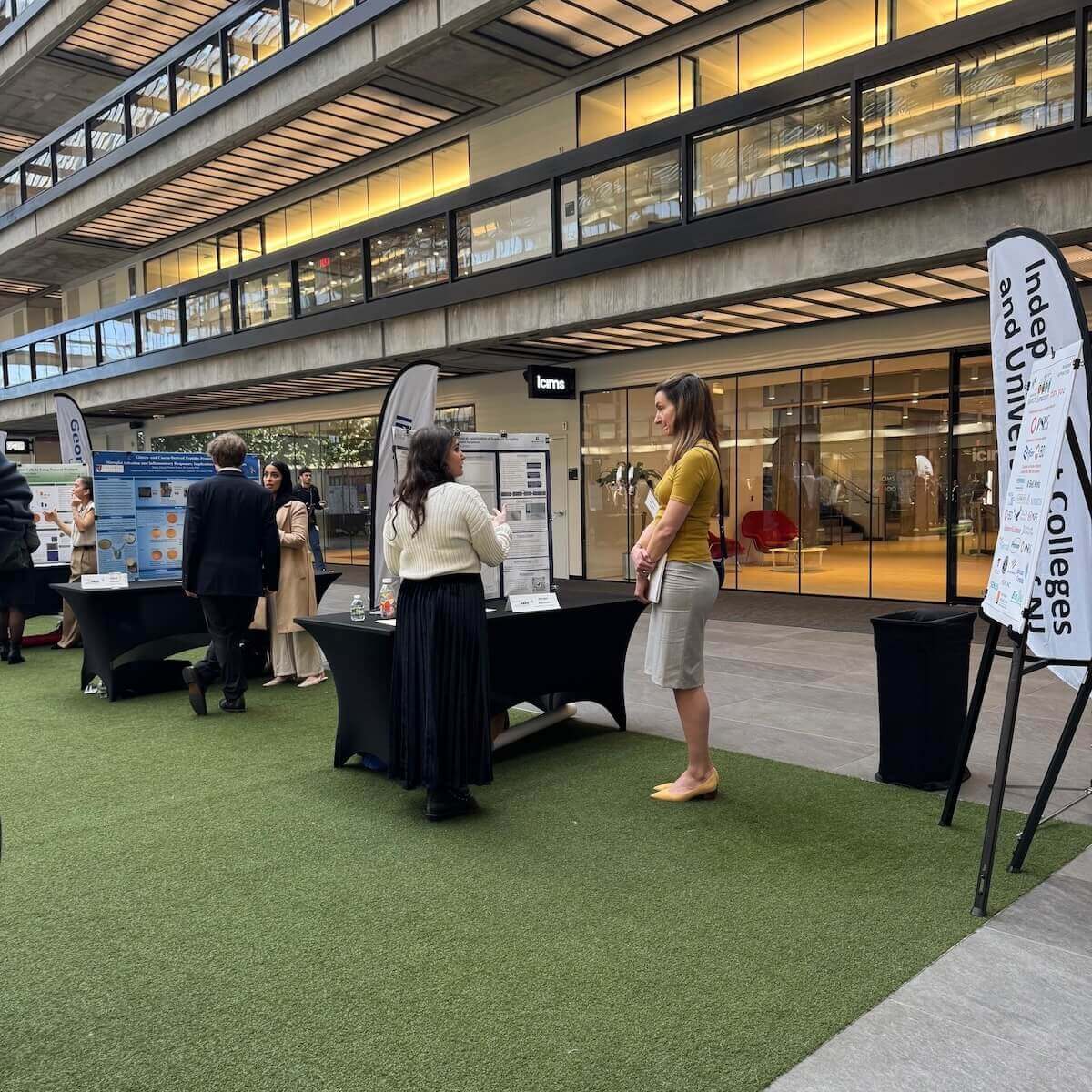Woman speaking to another woman about her poster presentation