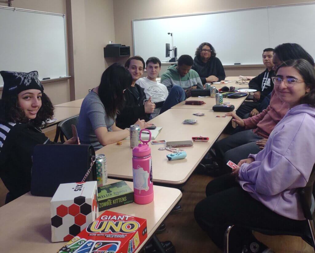 Group of students playing card games at a table.