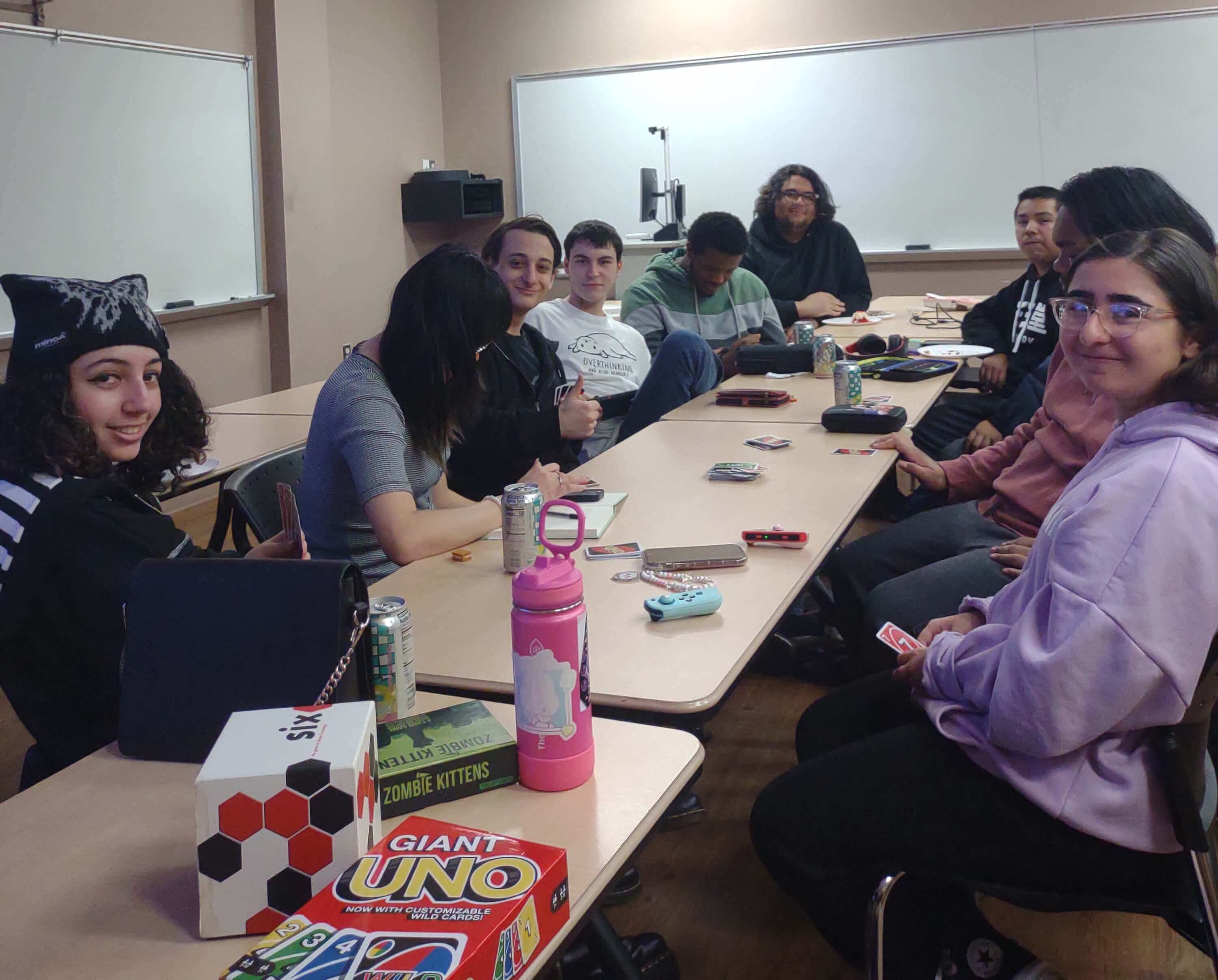 Group of students playing card games at a table.