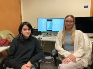 Two students demonstrating the app they created