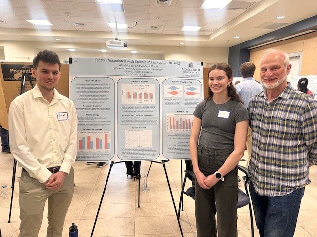 Professor and two students near a poster presentation