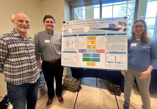 Two students and professor near poster presentation