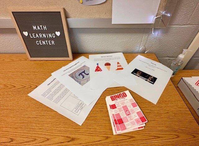 Papers spread on a table relating to the mathematical concept of pi.