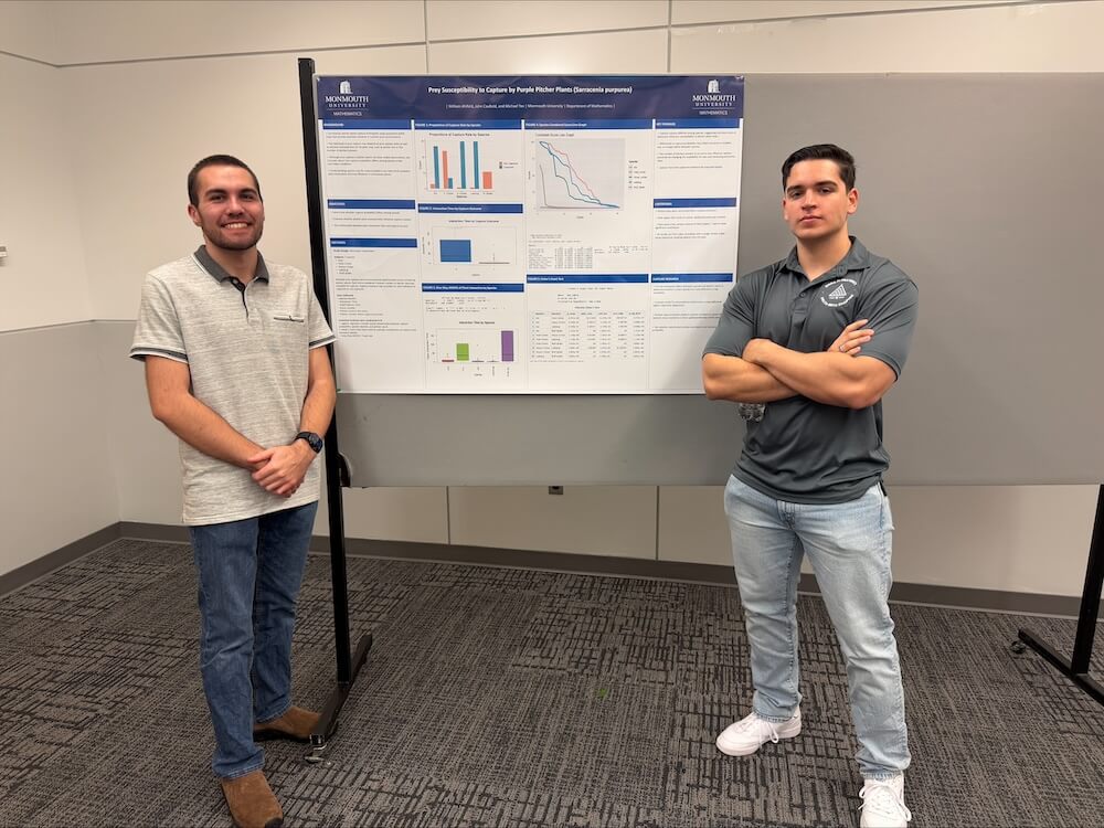 Two men standing near poster presentation