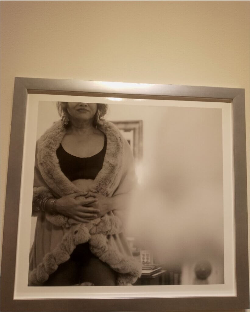 Framed black and white photo of a person facing the viewer, eyes out of frame.