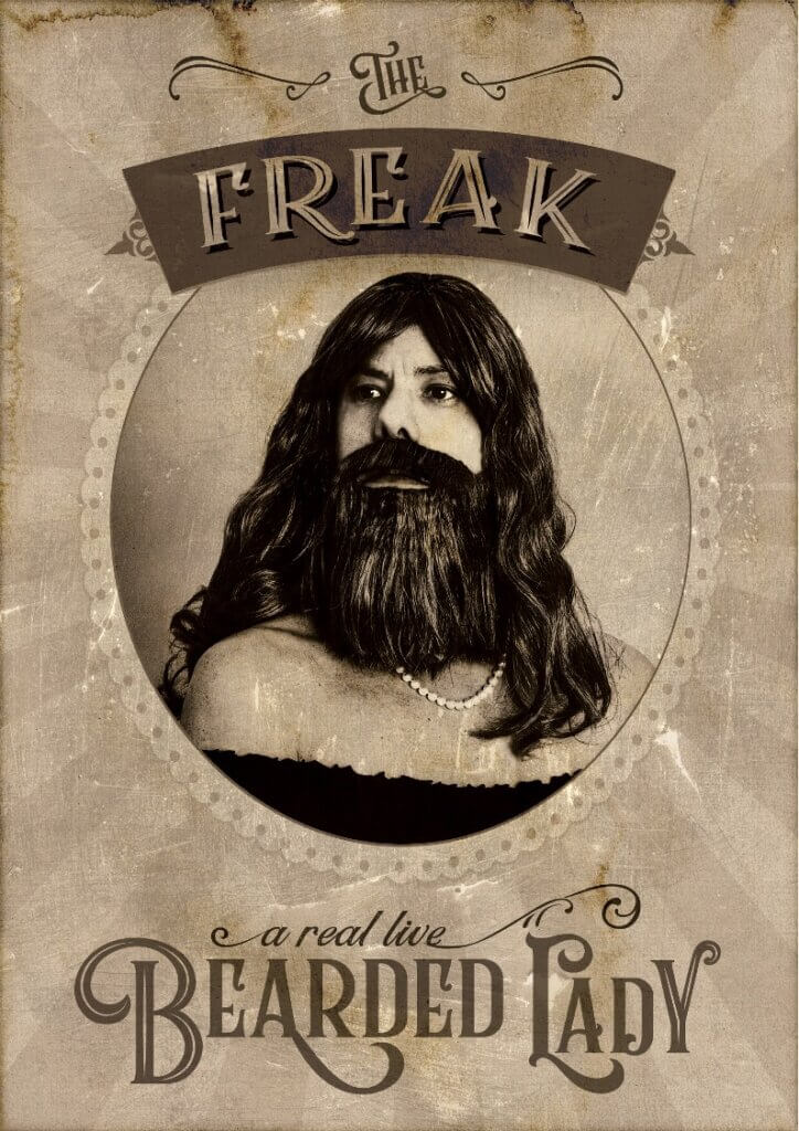 A photo done in the style of an old-time circus advertisement, showing the artist with long hair and a full beard, wearing a a pearl necklace and a dress with shoulder's exposed. The text reads "The Freak: a real live bearded lady".