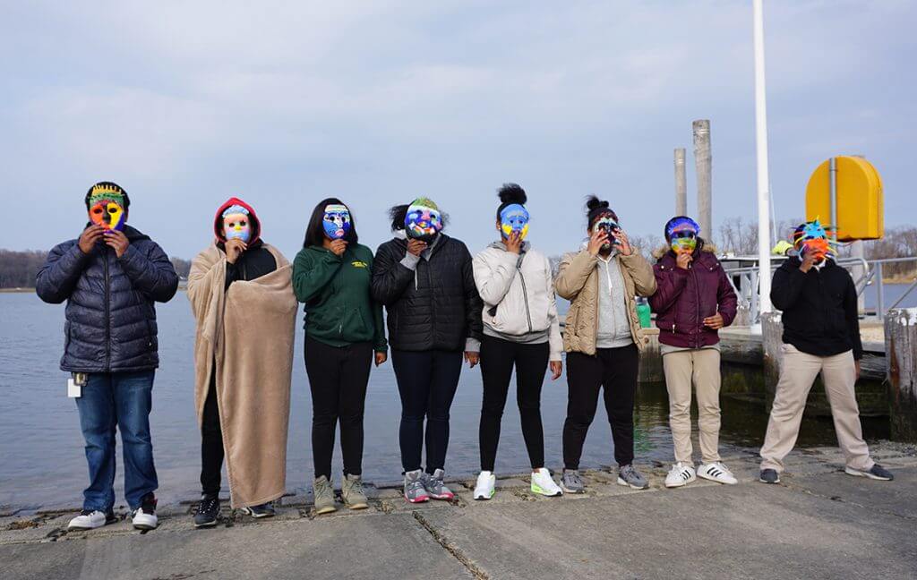 Photo students lined up each wearing a colorful face mask