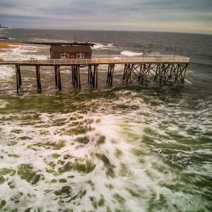 Photo of storm waves along beach pier