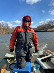 Photo of UCI Marine Scientist Jim Nickels guiding a Monmouth University boat on Crosswicks Creek.