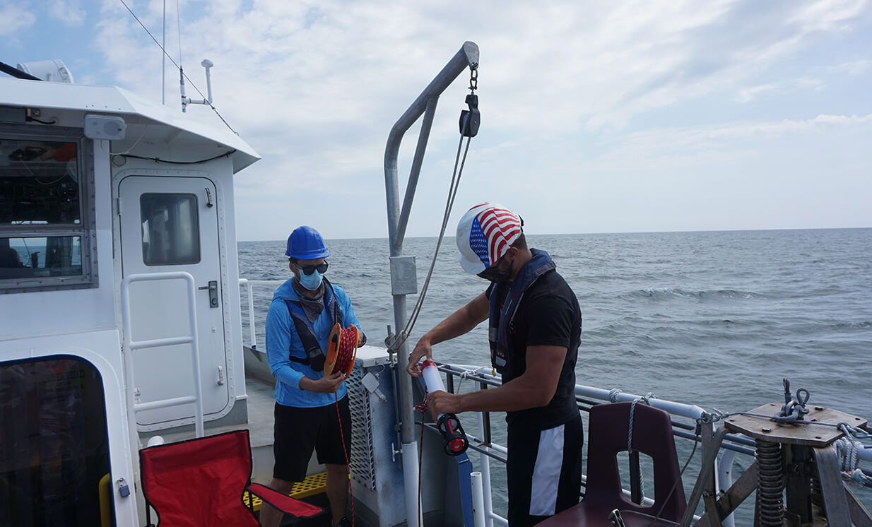 Photo shows the research team taking some readings in the water with their own equipment to make sure the glider’s data is matching up accurately
