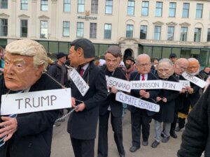 Photo of protestors dressed in masks of various world leaders to show their displeasure with these leaders.