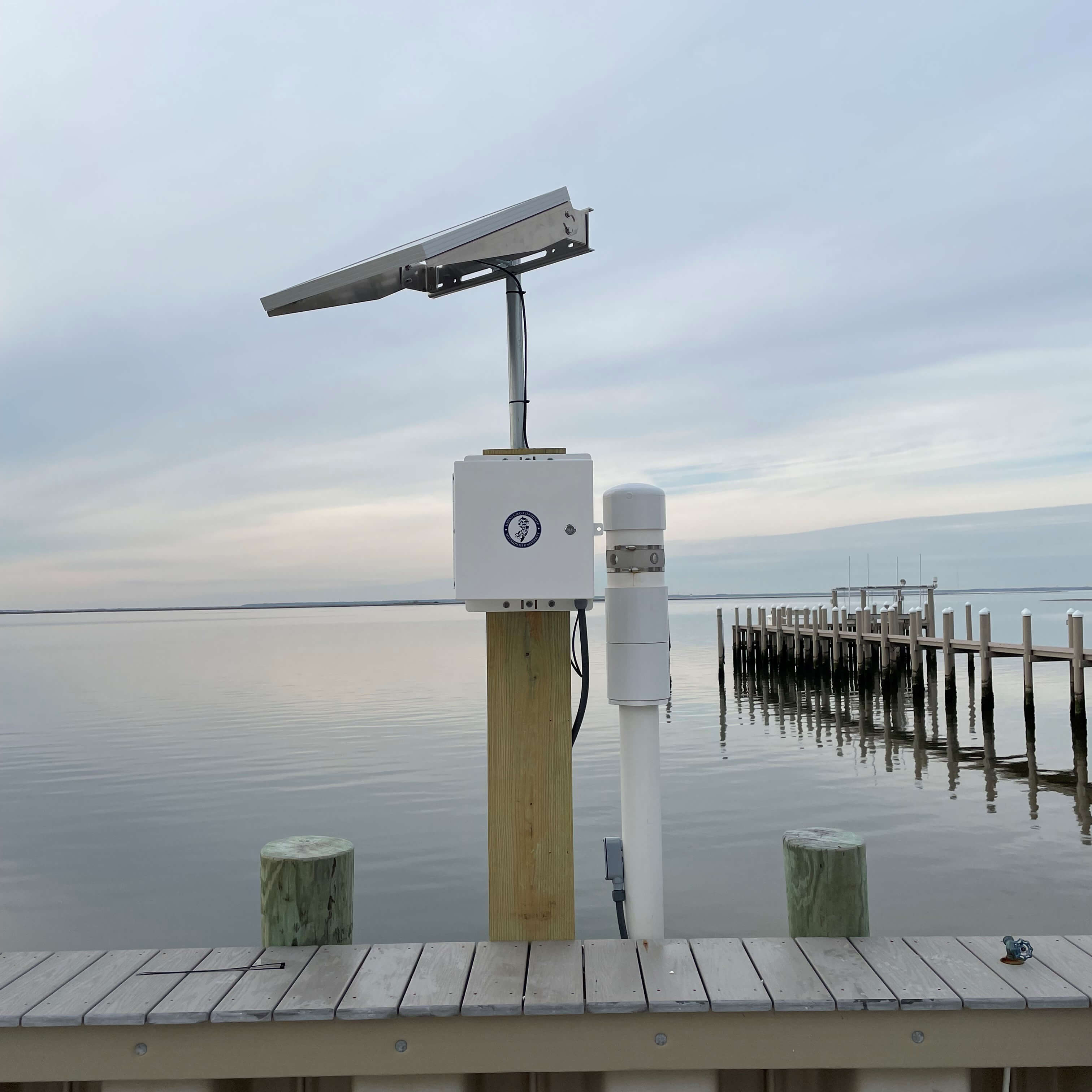 Tide gauge equipment in front of a calm waterfront
