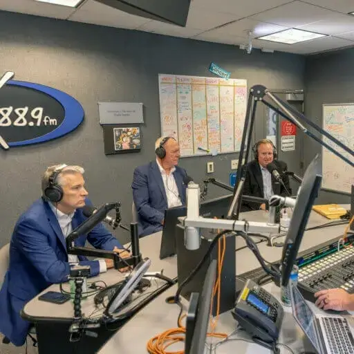 Patrick Leahy, Tony MacDonald, and Tom Herrington seated in the WMCX radio station