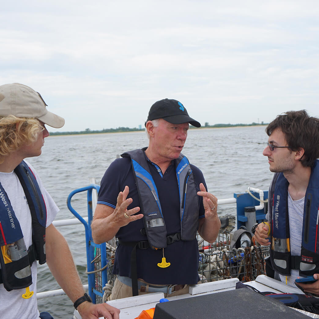 MacDonald speaks to two students aboard a vessel