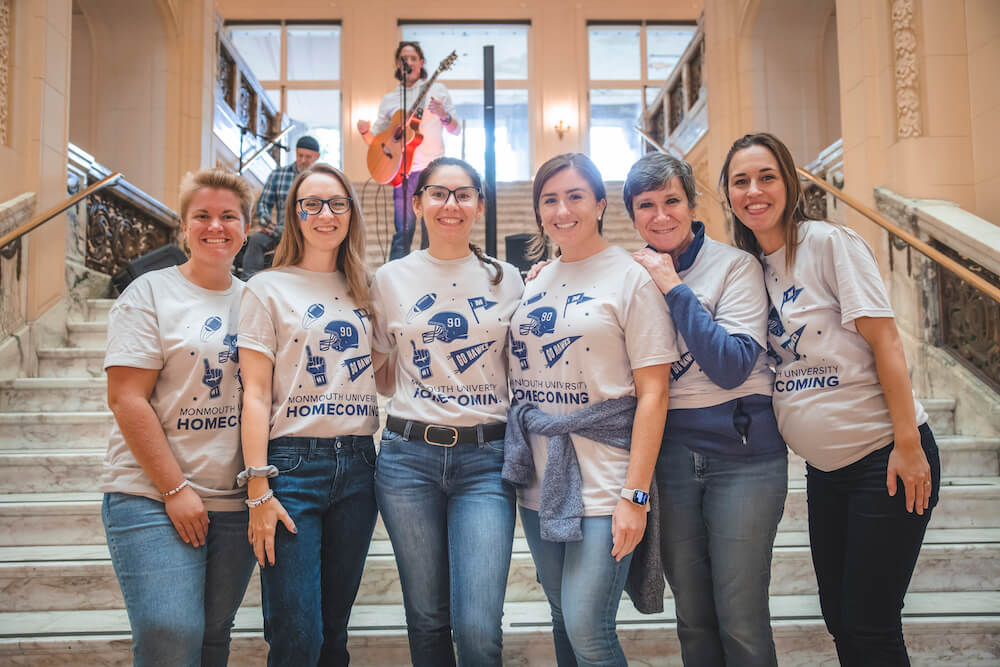 The Alumni Engagement and Annual Giving team posing for a photo on the steps of the Great Hall.